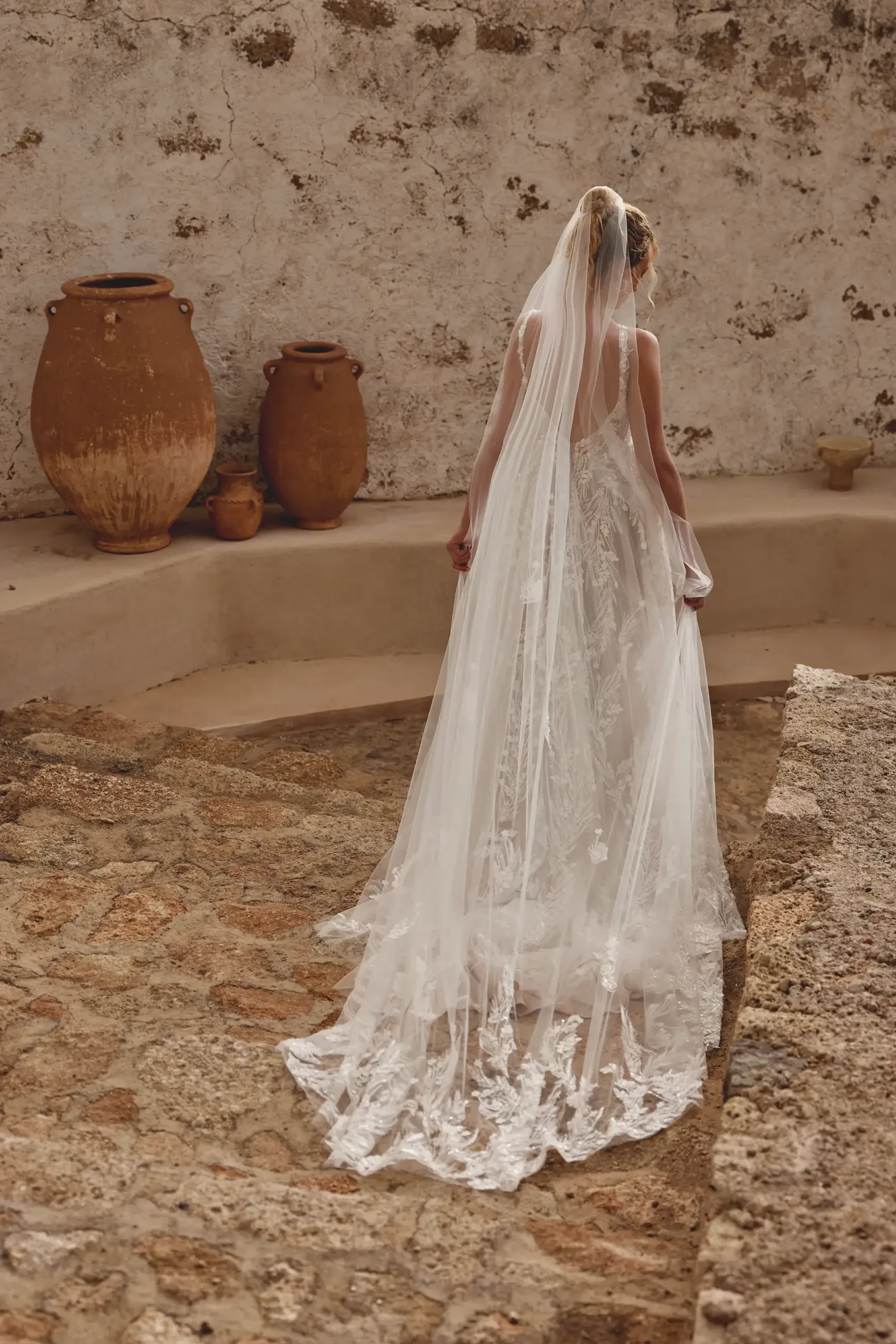 Model is wearing a sleeveless a-line wedding dress with a v-neckline