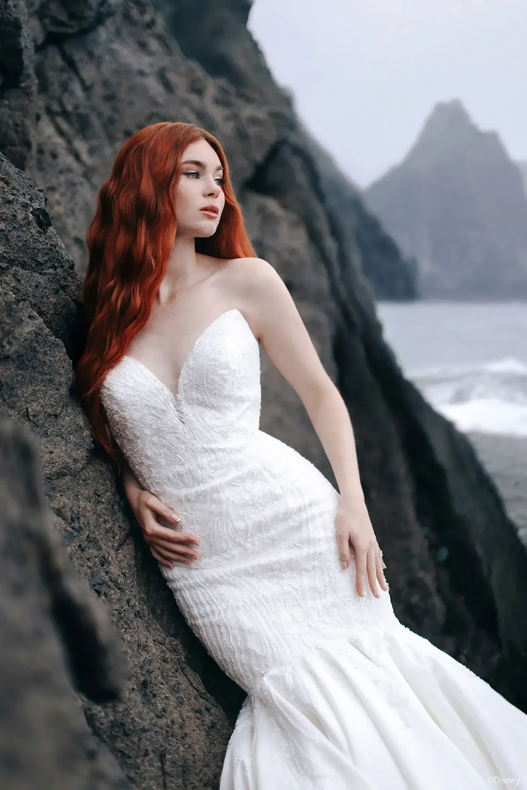 Model is wearing a strapless mermaid wedding dress with a plunging neckline