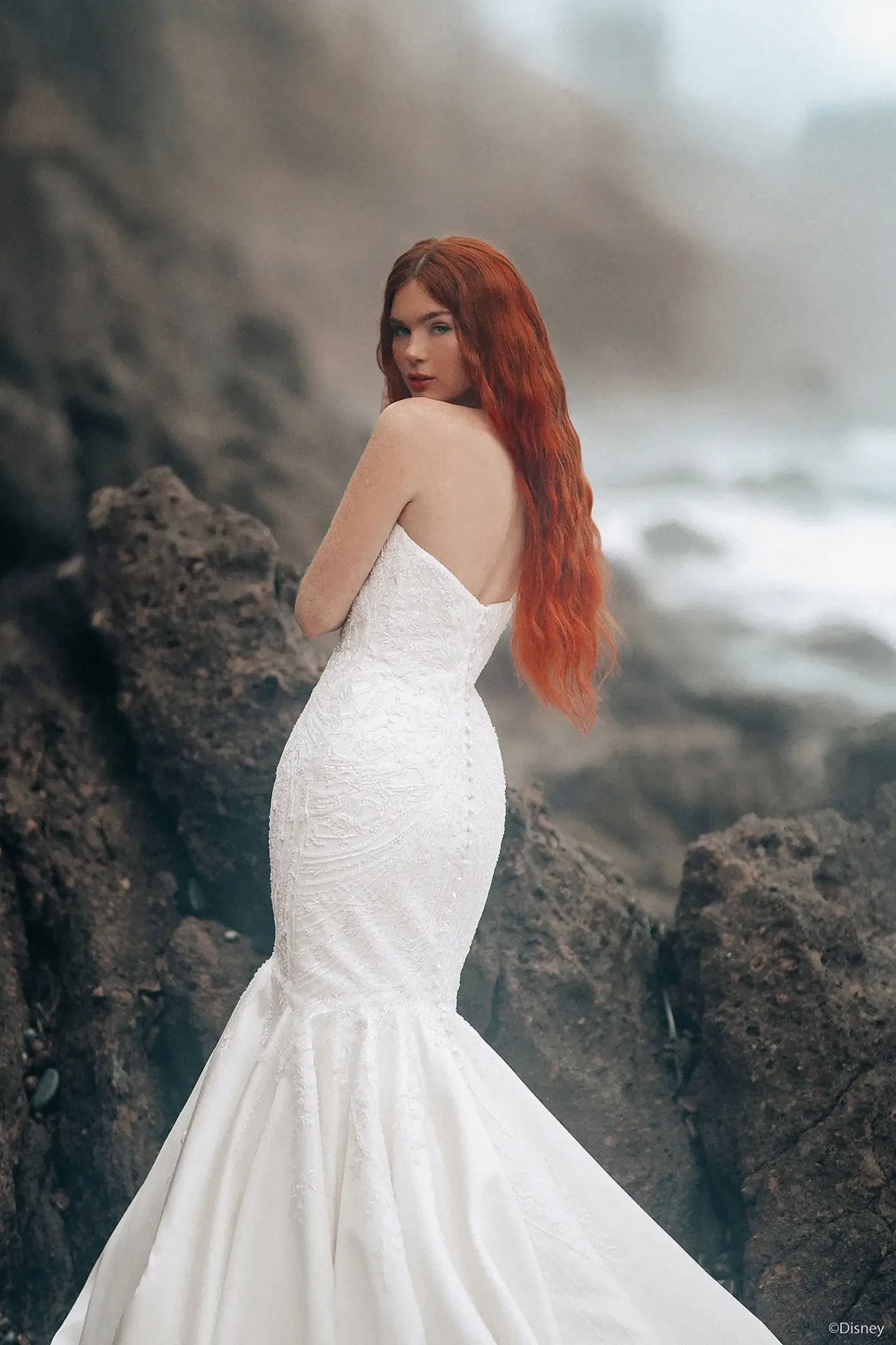 Model is wearing a strapless mermaid wedding dress with a plunging neckline